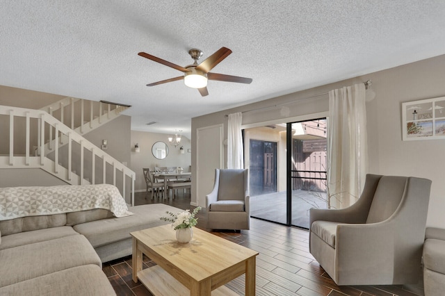 living room with dark hardwood / wood-style floors, a textured ceiling, and ceiling fan with notable chandelier