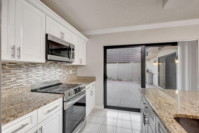 kitchen featuring light stone counters, white cabinets, a textured ceiling, and appliances with stainless steel finishes