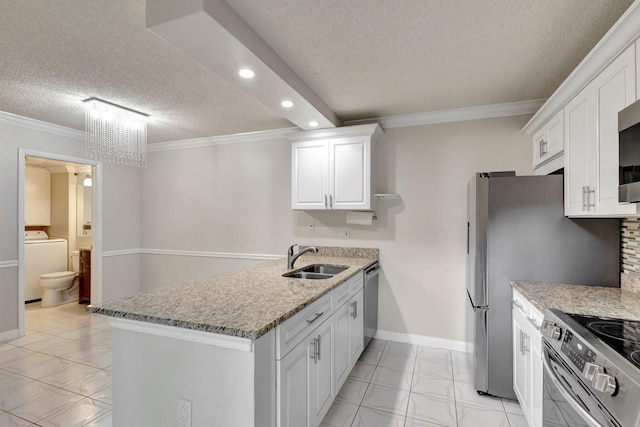 kitchen with light stone counters, a textured ceiling, sink, white cabinets, and washer / clothes dryer