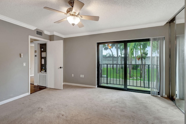 carpeted spare room with ceiling fan, a textured ceiling, and ornamental molding