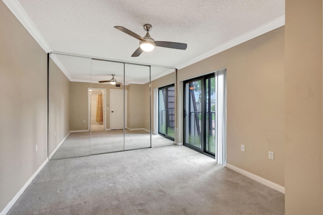 unfurnished bedroom with light carpet, ornamental molding, a textured ceiling, ceiling fan, and a closet