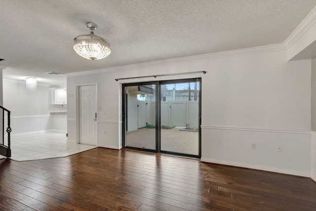 spare room with hardwood / wood-style floors, ornamental molding, and a textured ceiling