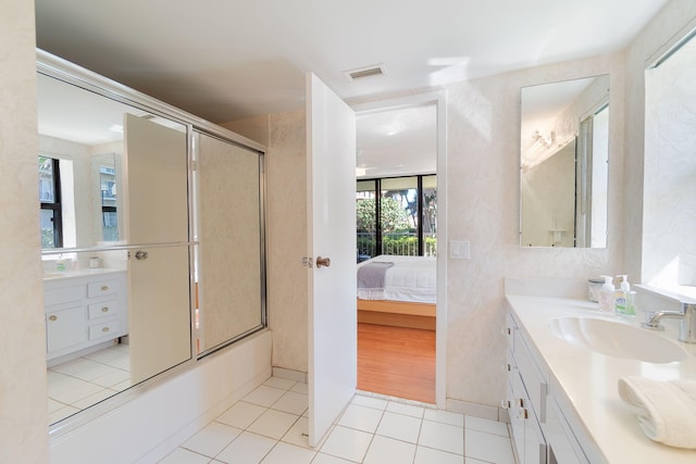 bathroom featuring tile patterned flooring, vanity, and combined bath / shower with glass door