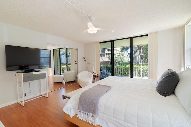 bedroom featuring a textured ceiling, access to outside, wood-type flooring, and ceiling fan