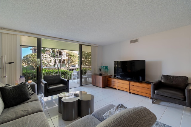 living room featuring expansive windows, a textured ceiling, and light tile patterned floors