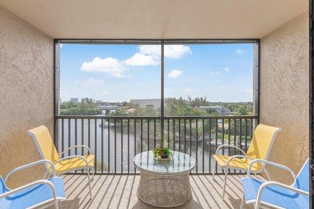 sunroom / solarium featuring a water view and plenty of natural light