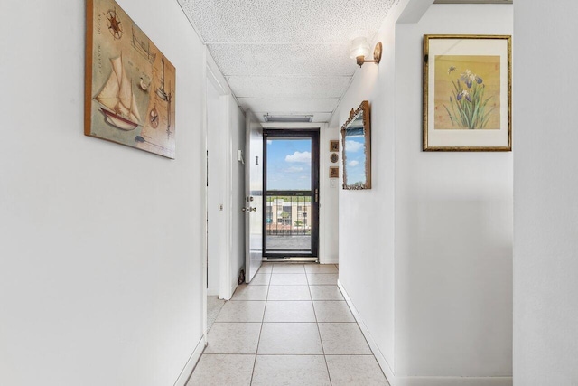 hallway featuring a wall of windows and light tile patterned floors