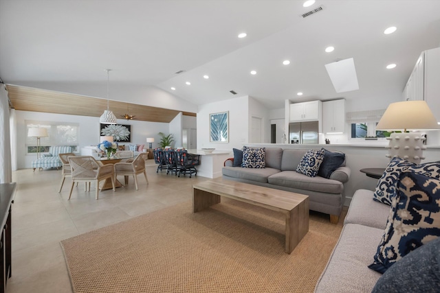 living room featuring vaulted ceiling with skylight and a wealth of natural light