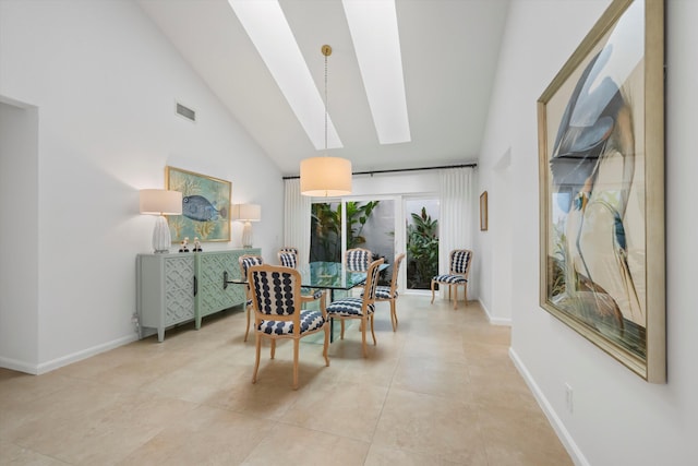 tiled dining space with high vaulted ceiling and a skylight