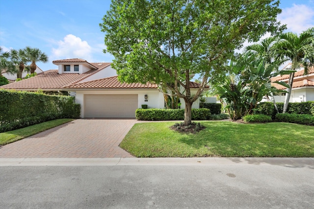 mediterranean / spanish house with a front yard and a garage