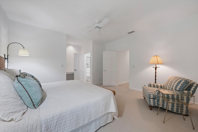 bedroom with light carpet, ensuite bath, and ceiling fan