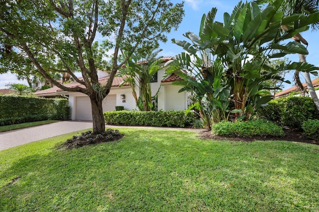 view of front of home with a garage and a front lawn