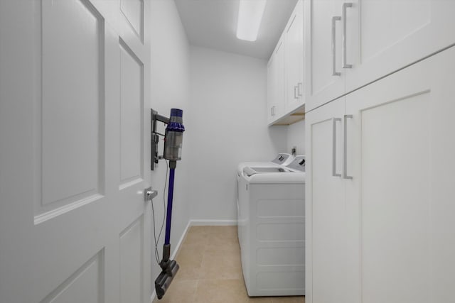 laundry area with washer and clothes dryer, light tile patterned floors, and cabinets