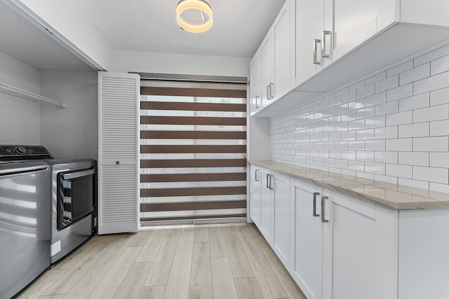 laundry room featuring light hardwood / wood-style flooring and washing machine and clothes dryer