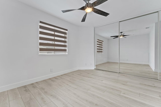 unfurnished bedroom with ceiling fan, a closet, and light wood-type flooring