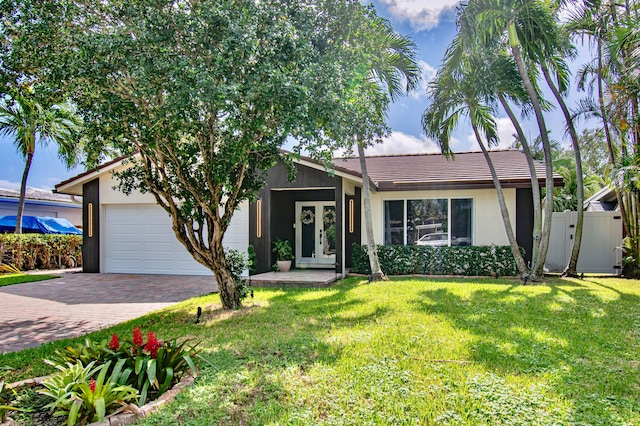 single story home featuring a front yard and a garage