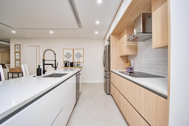 kitchen with light brown cabinets, sink, wall chimney exhaust hood, appliances with stainless steel finishes, and light tile patterned flooring