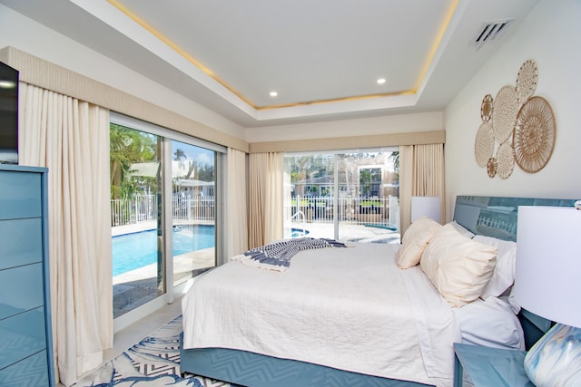 bedroom featuring access to exterior and a tray ceiling