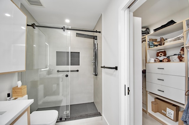 bathroom with vanity, a shower with shower door, and toilet