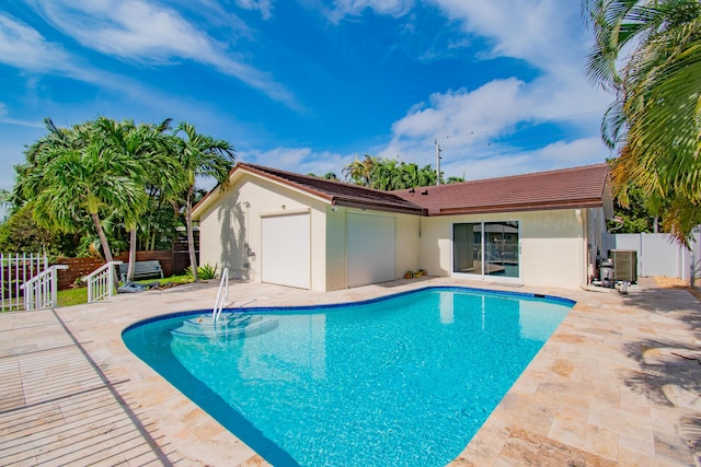 view of swimming pool with central air condition unit and a patio