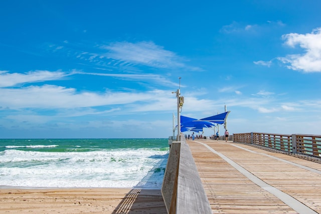 view of dock featuring a view of the beach and a water view