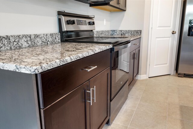 3526 Joshua Tree St, Palm Springs, FL 33461 - kitchen with appliances with stainless steel finishes, dark brown cabinets, light tile patterned floors, light stone countertops, and baseboards