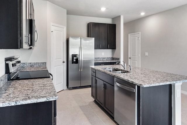 kitchen with stainless steel appliances, light tile patterned flooring, an island with sink, and sink