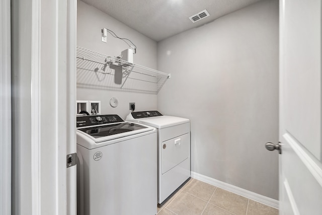 laundry room with separate washer and dryer and light tile patterned floors