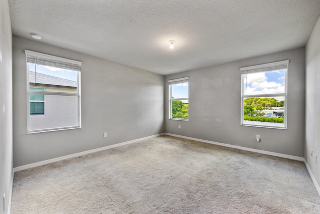 carpeted spare room with a textured ceiling