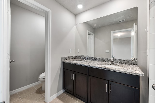 bathroom featuring vanity, tile patterned floors, toilet, and a textured ceiling