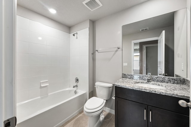 full bathroom with vanity, a textured ceiling, tiled shower / bath combo, tile patterned flooring, and toilet