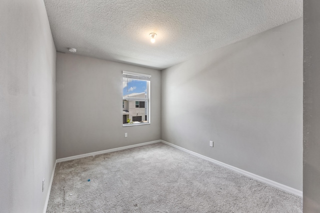 empty room featuring a textured ceiling and light colored carpet