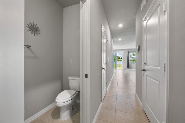 bathroom featuring toilet, a textured ceiling, and tile patterned floors