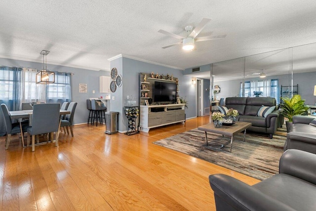 27 Lake Vista Trl Unit 107, Port Saint Lucie, FL 34952 - living room with ceiling fan, a textured ceiling, wood finished floors, healthy amount of natural light, and ornamental molding