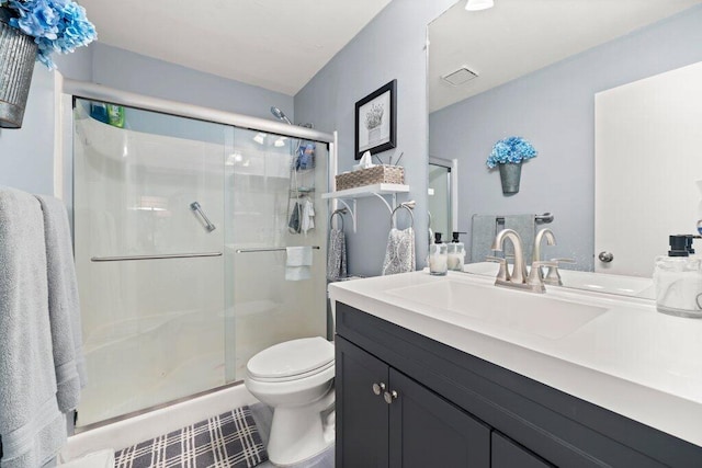 bathroom with walk in shower, vanity, and toilet