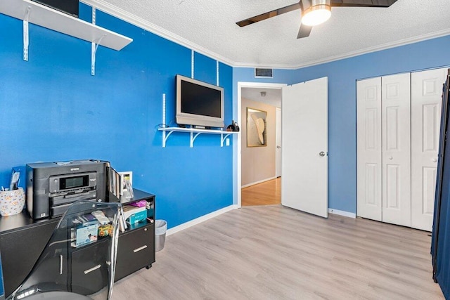 office space featuring hardwood / wood-style floors, ceiling fan, a textured ceiling, and ornamental molding