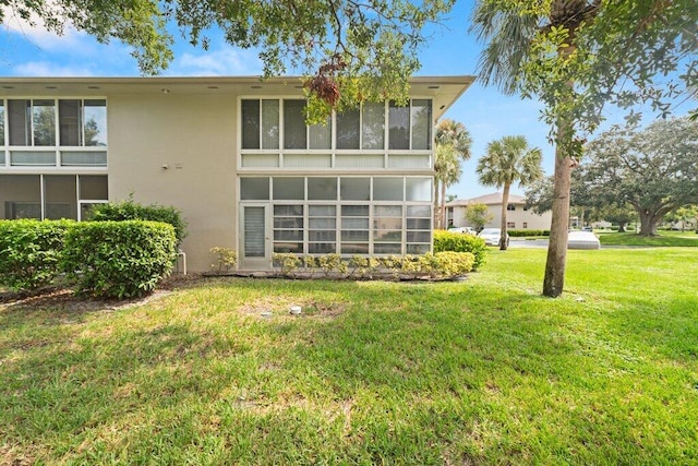27 Lake Vista Trl Unit 107, Port Saint Lucie, FL 34952 - back of property with stucco siding and a yard
