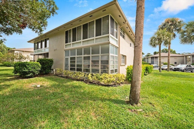 rear view of property featuring a sunroom and a yard