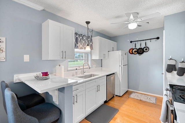 27 Lake Vista Trl Unit 107, Port Saint Lucie, FL 34952 - kitchen with stainless steel dishwasher, stove, a ceiling fan, white cabinets, and a sink