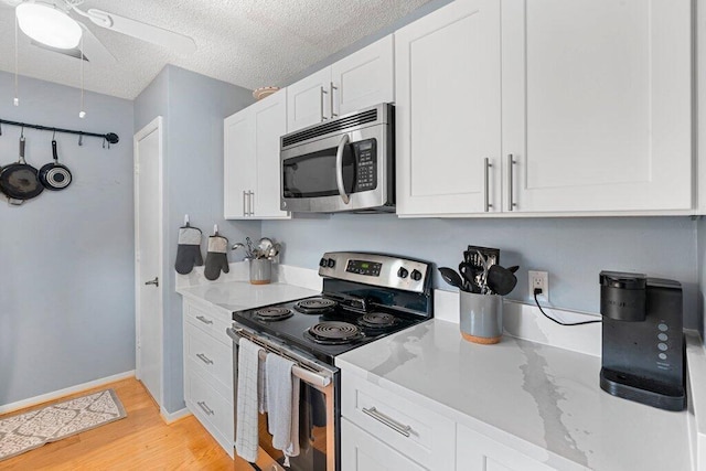 27 Lake Vista Trl Unit 107, Port Saint Lucie, FL 34952 - kitchen featuring stainless steel appliances, light wood-style flooring, a ceiling fan, white cabinetry, and a textured ceiling