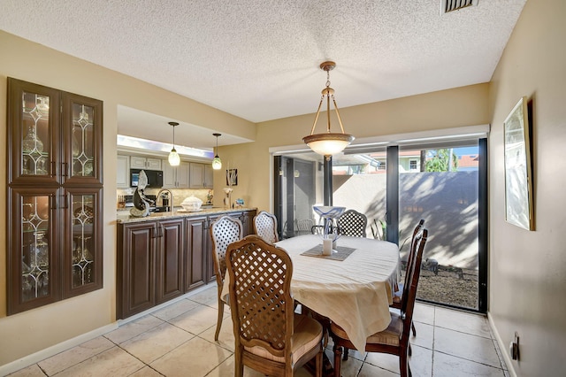 dining area featuring visible vents, a textured ceiling, baseboards, and light tile patterned floors