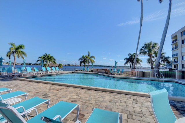 view of pool with a patio area and a water view