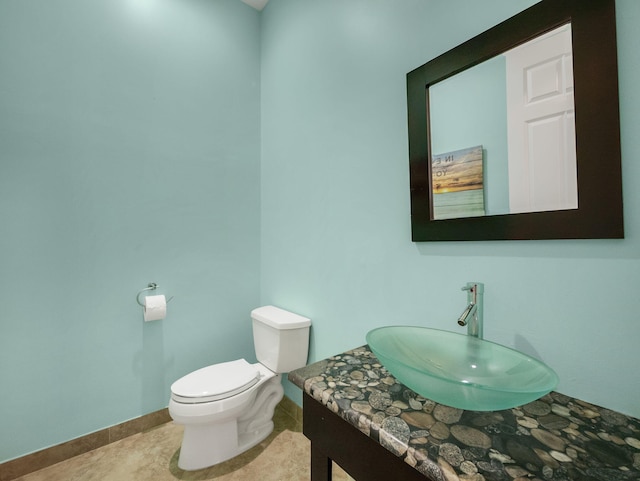 bathroom featuring toilet, vanity, and tile patterned flooring