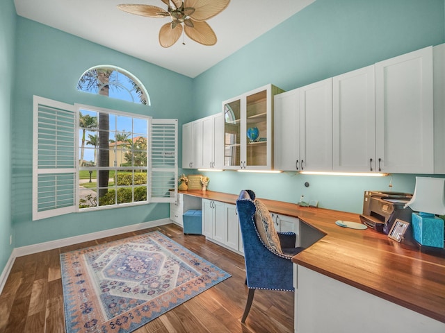 office space featuring hardwood / wood-style floors, built in desk, and ceiling fan