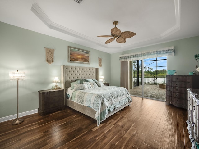 bedroom featuring dark wood-type flooring, a raised ceiling, ceiling fan, and access to exterior