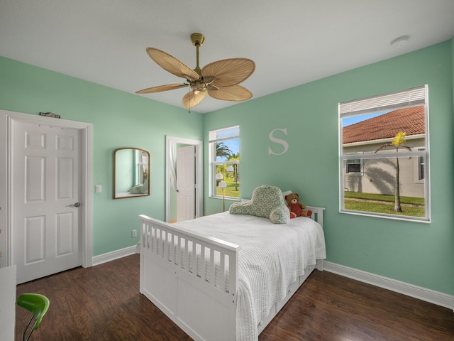 bedroom with ceiling fan, multiple windows, and dark hardwood / wood-style flooring