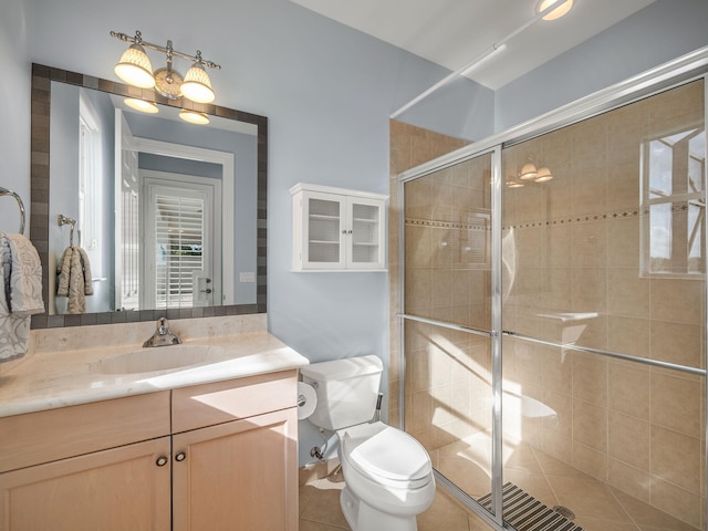 bathroom featuring vanity, walk in shower, tile patterned flooring, and toilet