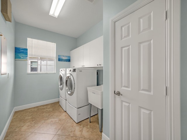 laundry room with cabinets, a textured ceiling, light tile patterned floors, sink, and washer and dryer