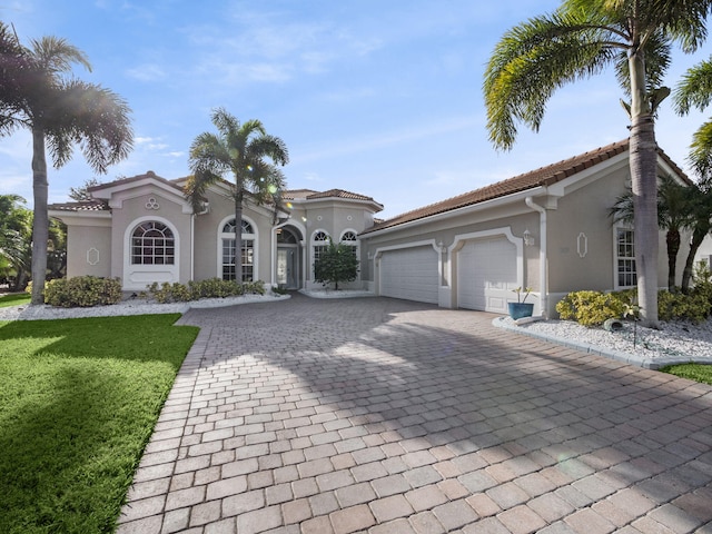 mediterranean / spanish house with a front lawn and a garage