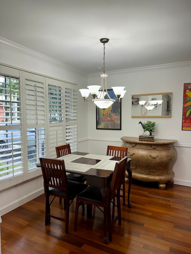 dining room featuring dark wood-type flooring, a chandelier, and crown molding